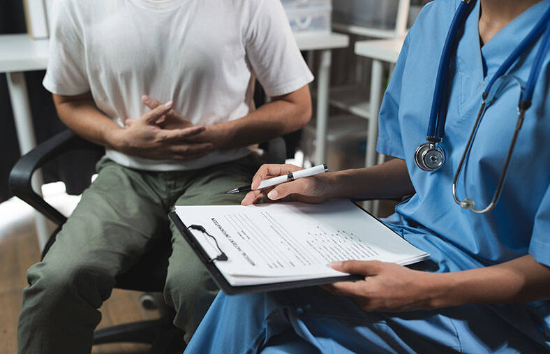 Patient holding stomach while talking to a provider
