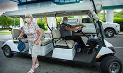 Courtesy cart at Main Entrance with masked patient stepping off cart