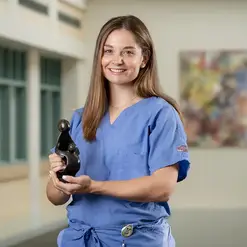 A female health care provider holding a Daisy Award statuette