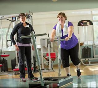 Patient and therapist work out in gym