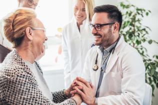 A smiling patient with smiling providers