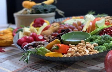 Harvest Board arranged with fresh vegetables, nuts, fruit and dips.