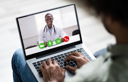 African American man interacting through telehealth with African American doctor