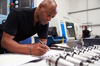 Engineer with pen and machinery