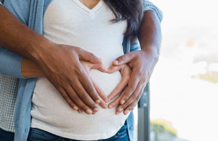 Pregnant woman and husband holding