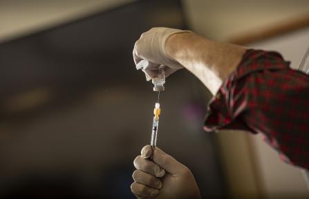 Vile being filled with vaccine