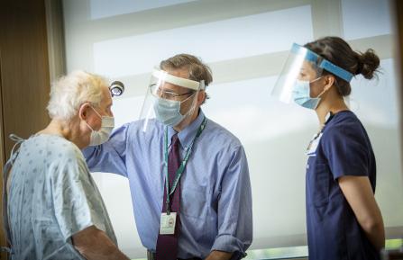 Shane Chapman and student evaluate a patient