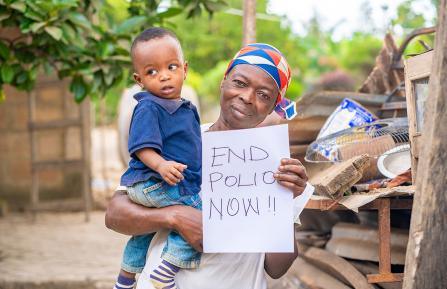 African-American mother holding a child that says "End Polio Now"