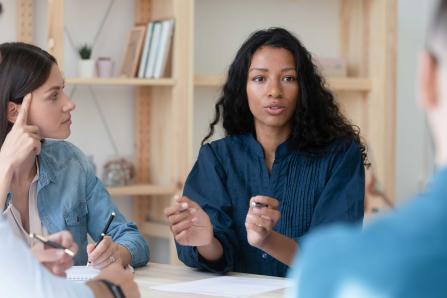 Four people having a discussion at a table 