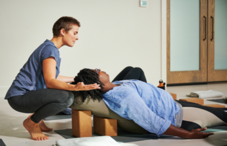 Kyla Pearce, PhD, MPH, supports a LoveYourBrain Yoga participant