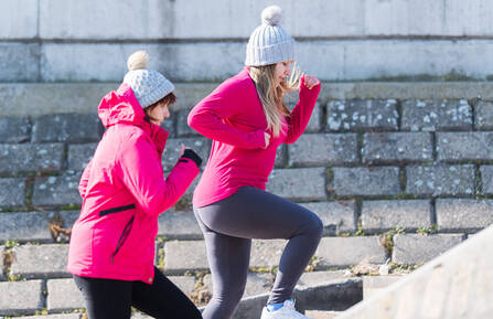 Two women exercising on steps