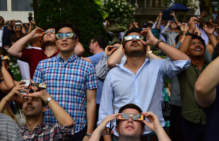 Crowd of people wearing eclipse glasses