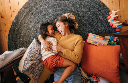 Top view of a mother and her daughter laughing cheerfully 
