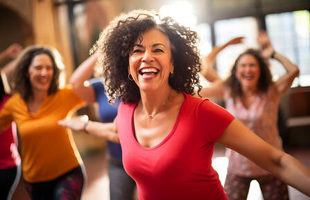 Happy women enjoying a joyful dance class, candidly expressing their active lifestyle through Zumba