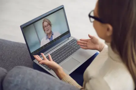 Patient speaking with a doctor during a video appointment on a laptop