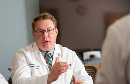 Bjoern D. Suckow, MD, MS, talking with a colleague