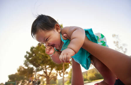 Baby being lifted up into the sky