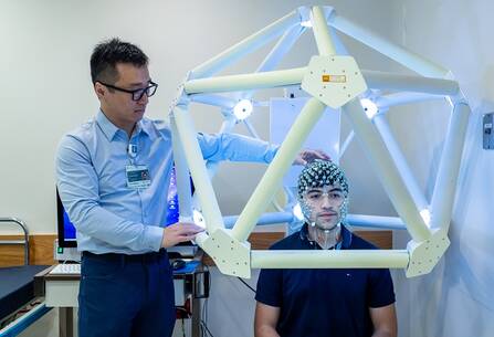 Yinchin Song, PhD performs a high-density electro encephalogram (HDEEG) on a patient.