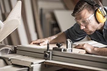 Woodworker cutting boards on table saw