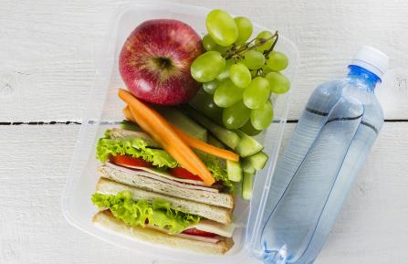 A healthy lunch in a box with a bottle of water