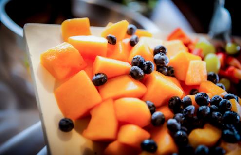 Cantaloupe cubes and blueberries on white platter.