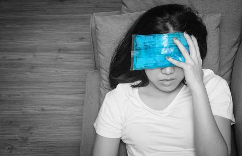 asian woman with icepack on her forehead