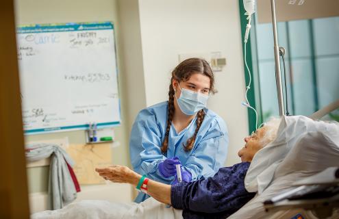 Devon Fortier, BSN, RN, treats a patient at Dartmouth-Hitchcock’s Norris Cotton Cancer Center (NCCC), where she was treated for leukemia as a young child.