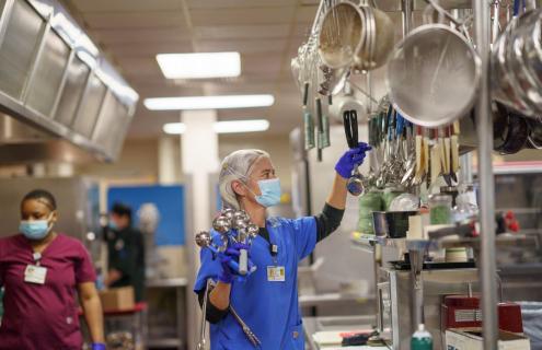 A woman works in the kitchen at DHMC.