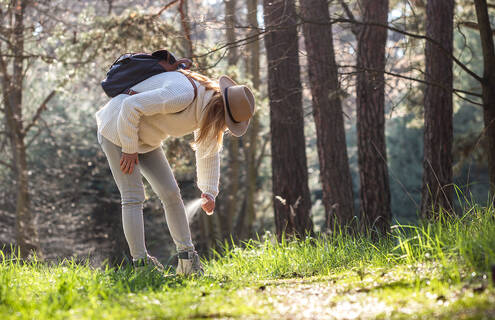 picture of woman spraying bug spray