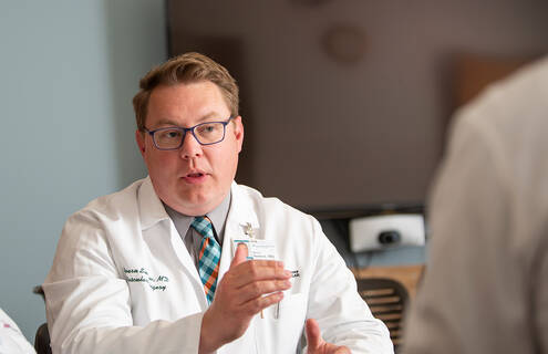 Bjoern D. Suckow, MD, MS, talking with a colleague