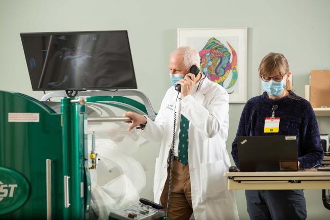 Doctors overseeing a patient getting treatment in a hyperbaric chamber
