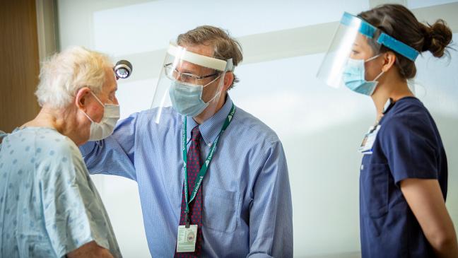 Dr. M. Shane Chapman and medical assistant Kate Yamahiro treat a dermatology patient. 