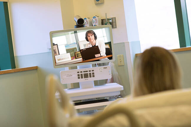 A patient having a TelePsychiatry appointment with a provider on a video screen 