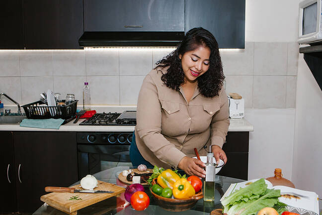 Weight Center: Latina woman preparing a meal on a kitchen counter