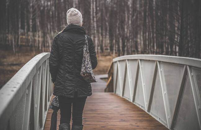 Woman walking across a bridge