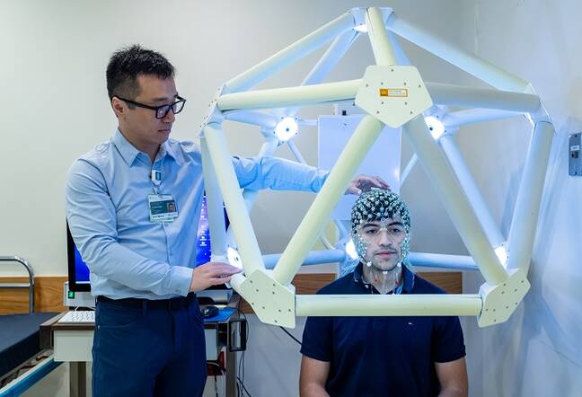 Yinchin Song, PhD performs a high-density electro encephalogram (HDEEG) on a patient.