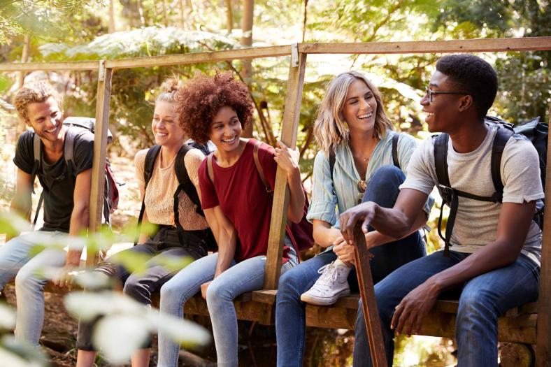 A group of happy hikers sitting on a bridge