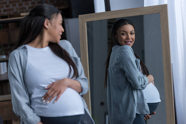 Pregnant woman in front of a mirror